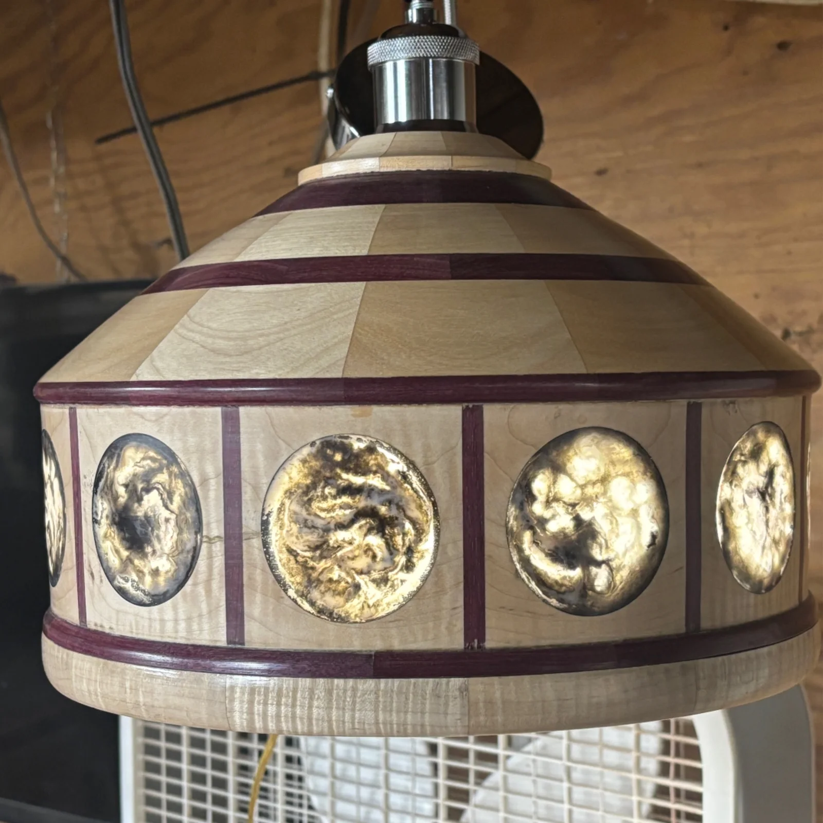 Purpleheart and maple pendulum lamp with a broad wooden shade and circular epoxy inlays