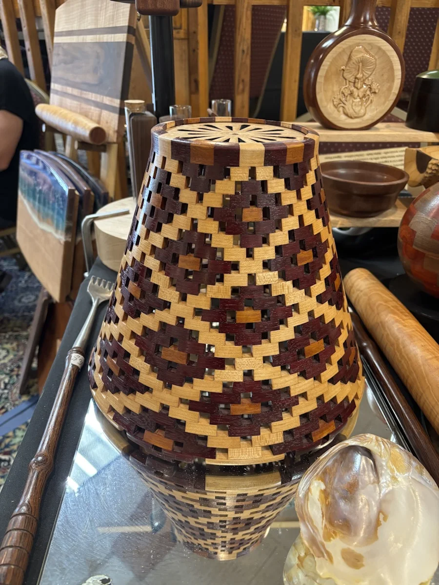 Angled view of the lamp shade showing its open weave and fitted wooden top